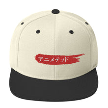 Load image into Gallery viewer, Natural and Black snapback hat with Animeted Brand&#39;s red paintbrush logo written in Japanese Katakana.
